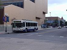 A white low-floor city bus on an empty city street