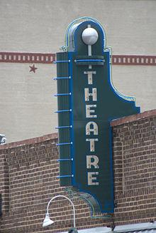 Photograph of a old theater sign on a rustic building.
