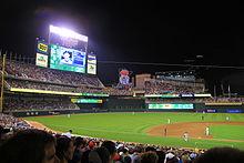 Baseball field at night, scoreboard displays a player, Twins
